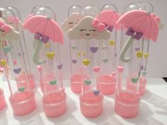 there are many pink and white umbrellas in the vases on the table together