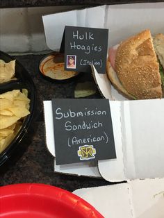 sandwiches and chips are on the counter at a fast food restaurant with signs that say submision sandwich american