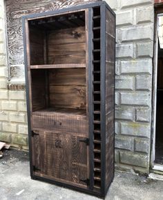 an old wooden storage cabinet sitting in front of a brick building with its doors open