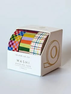 washi tape in a box on a white surface with the letter q printed on it