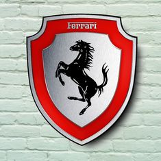 a red and white ferrari emblem mounted on a brick wall with the word ferrari below it