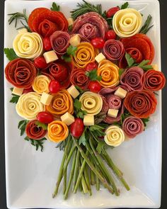 a white plate topped with lots of different types of flowers on top of each other