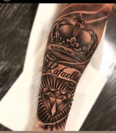 a man's arm with a crown and diamond tattoo on it, which reads rotalella