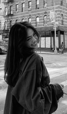 a woman is standing on the street with her back to the camera and she's smiling