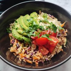 a bowl filled with rice and vegetables on top of a table