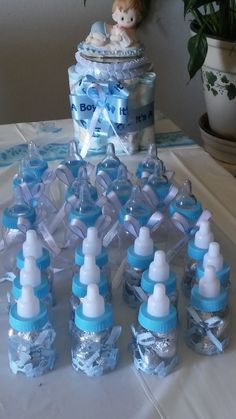 baby bottles are arranged on a table next to a potted plant and a teddy bear