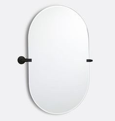 an oval mirror hanging on the wall with black handles and a round mirror above it