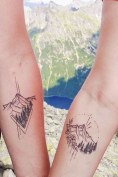 two people with matching tattoos on their arms, one is holding the other's hand