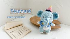 a crocheted elephant with a hat on it's head next to a calendar