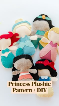 a hand is holding several small stuffed dolls in different colors and sizes on a white surface