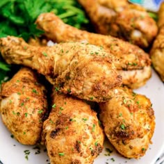 chicken wings and greens on a white plate