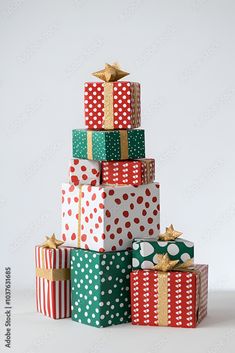 a stack of wrapped presents sitting on top of each other in different colors and patterns