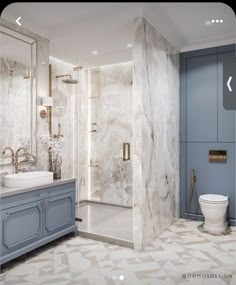 a bathroom with marble walls and flooring, blue cabinetry, and a walk in shower