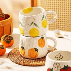 two cups with lemons painted on them are sitting on a wicker place mat