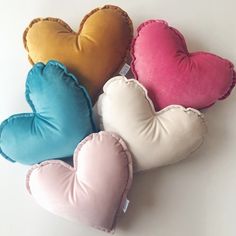 four heart shaped pillows sitting next to each other