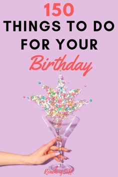 someone holding a martini glass filled with sprinkles and the words, 150 things to do for your birthday