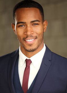 a close up of a person wearing a suit and tie