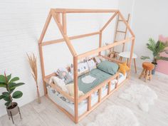 a wooden doll house bed in a room with white brick walls and flooring, along with potted plants