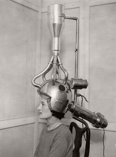 a woman with a helmet on her head is looking at a machine in the air