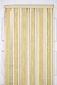 a yellow and white striped curtain hanging on the side of a door