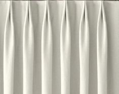 white curtains hanging on the side of a window in front of a black curtain rod