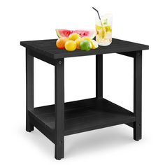 a black table with fruit and drinks on it