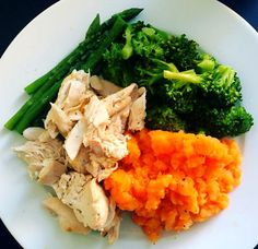 a white plate topped with broccoli, carrots and chicken