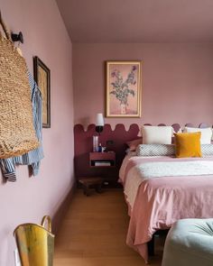 a bedroom with pink walls and wooden floors