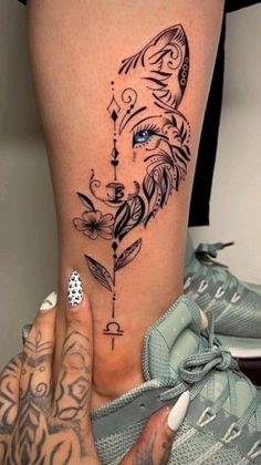 a woman's leg with a tattoo on it and an arrow in the middle