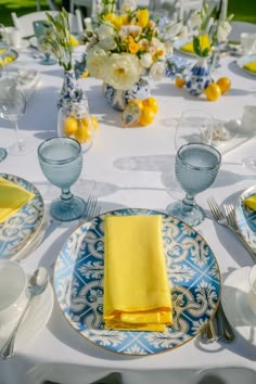 the table is set with blue and white plates, yellow napkins, and silverware