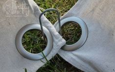 two circular rings are attached to the back of a chair in the grass with a white cloth covering them