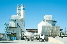 a cement mixer truck parked in front of a factory