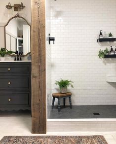 a bathroom with a sink, mirror and bathtub next to a wooden shelf filled with plants