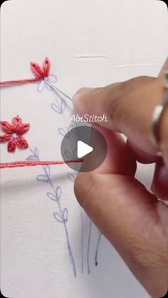 someone is stitching flowers on a piece of paper