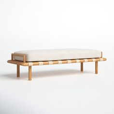 a wooden bench with a white cushion on the top and bottom end, sitting against a white background