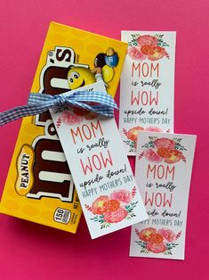 three candy bar tags tied to each other on a pink and yellow background with a blue ribbon