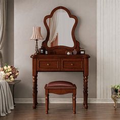 a dressing table with a mirror and stool in front of it on a hard wood floor