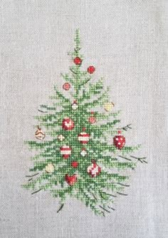 a cross stitch christmas tree with ornaments on it