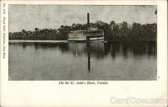 an old postcard with a boat on the water and trees in the back ground