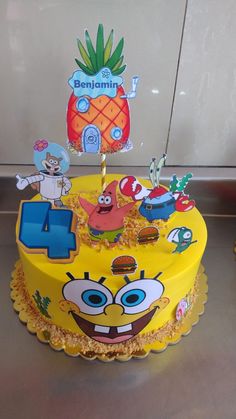 a spongebob themed birthday cake with pineapple topper and number 4 candles