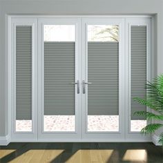 a white room with sliding glass doors and a potted plant