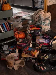 a pile of books sitting on top of a wooden floor next to a book shelf