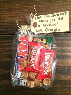 a bag filled with candy on top of a wooden table next to a note that says, thank the jackpot having you for a tache love, george