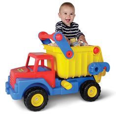 a little boy that is sitting in a toy truck