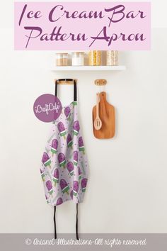 ice cream bar pattern apron hanging on the wall next to a cutting board and utensils