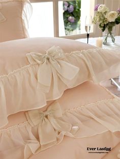 two ruffled pillows are stacked on top of each other