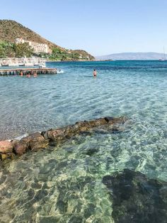 people are swimming in the clear blue water