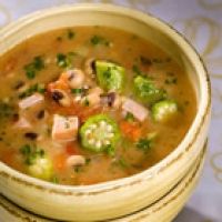 a bowl filled with soup and vegetables on top of a table