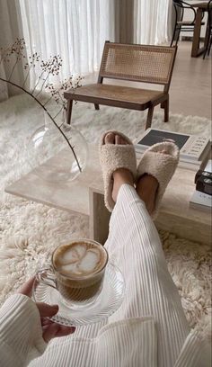 a person wearing slippers and holding a cup of coffee