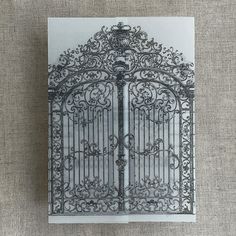 an intricate iron gate is shown on the side of a piece of paper that has been drawn